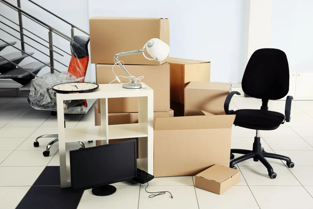 Skilled movers efficiently dismantling office furniture for relocation.